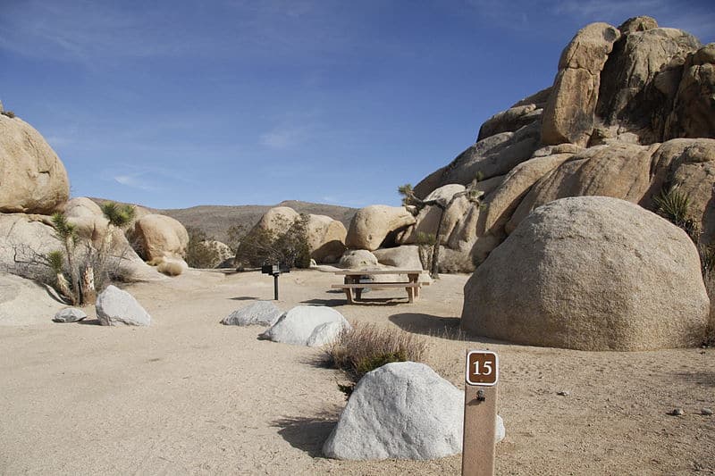 A campsite at Belle Campground in Joshua Tree surrounded by large boulders - where to stay in Joshua Tree