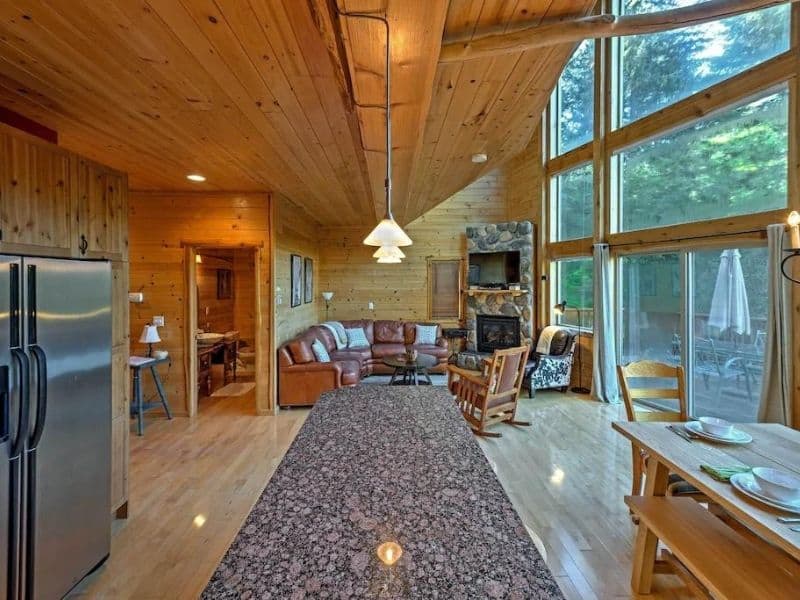 Interior living area of a Vrbo cabin rental near Mount Rainier WA with floor-to-ceiling windows and wood finishes.