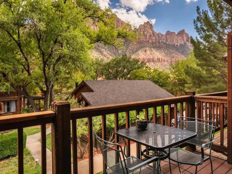 Private balcony with dining table and red rock views at Flanigan's Inn - a mid-range lodging option near Zion National Park