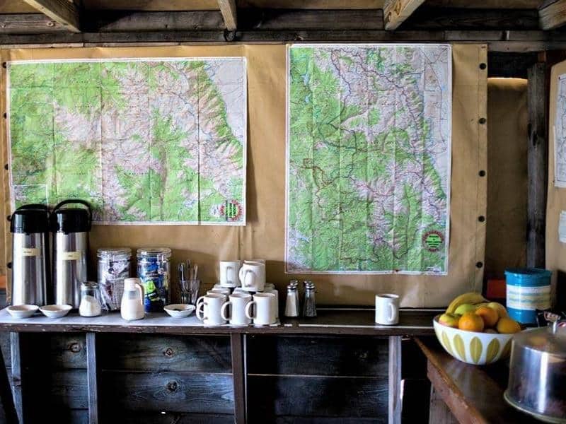 A beverage and coffee station at Bearpaw High Sierra Camp with large trail maps on display.