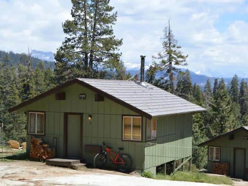 A single-story cabin at Montecito Sequoia Lodge with a mountain bike parked outside.
