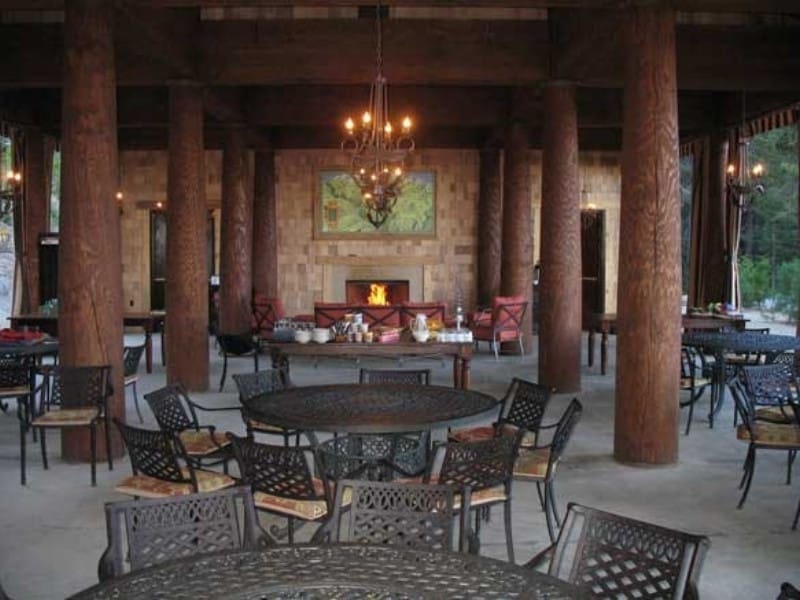 communal dining area with a stone fireplace and wooden tables at Sequoia High Sierra Camp. Glamping in Sequoia National Park.