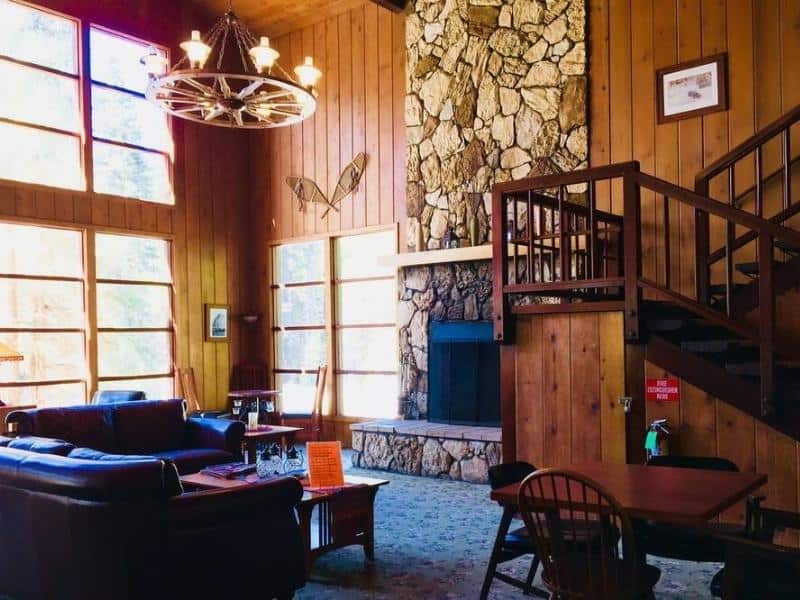 Lodge interior with high wooden ceilings, a chandelier, and a stone fireplace. Part of a guide on where to stay in Sequoia National Park.