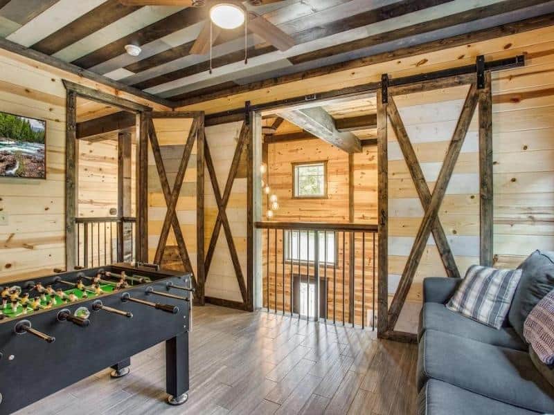 Game room with barn doors at Big Bear Luxury Cabin, Broken Bow