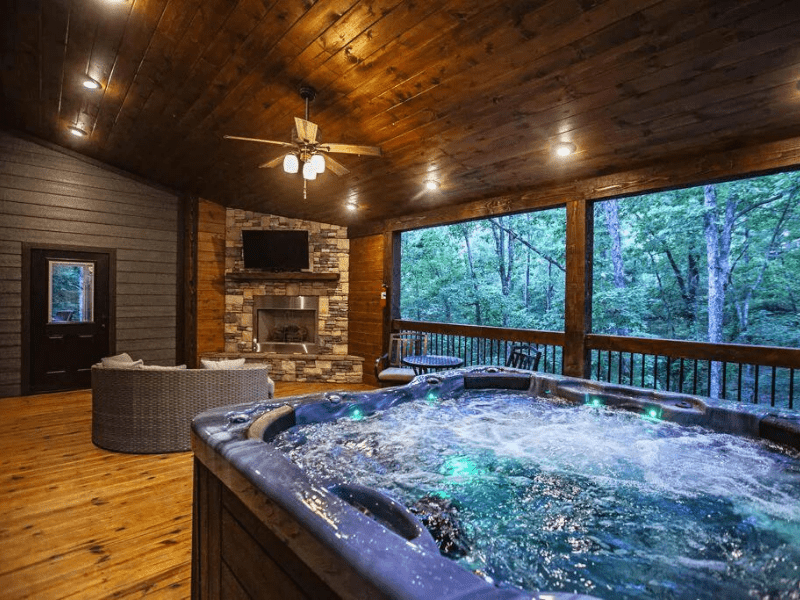 Outdoor patio with hot tub and fireplace - luxury cabins in Broken Bow, OK
