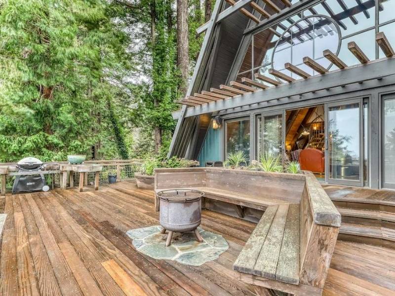 A-frame cabin with a large wooden deck surrounded by redwoods near Redwood National and State Park - part of a California National Parks Road Trip Itinerary