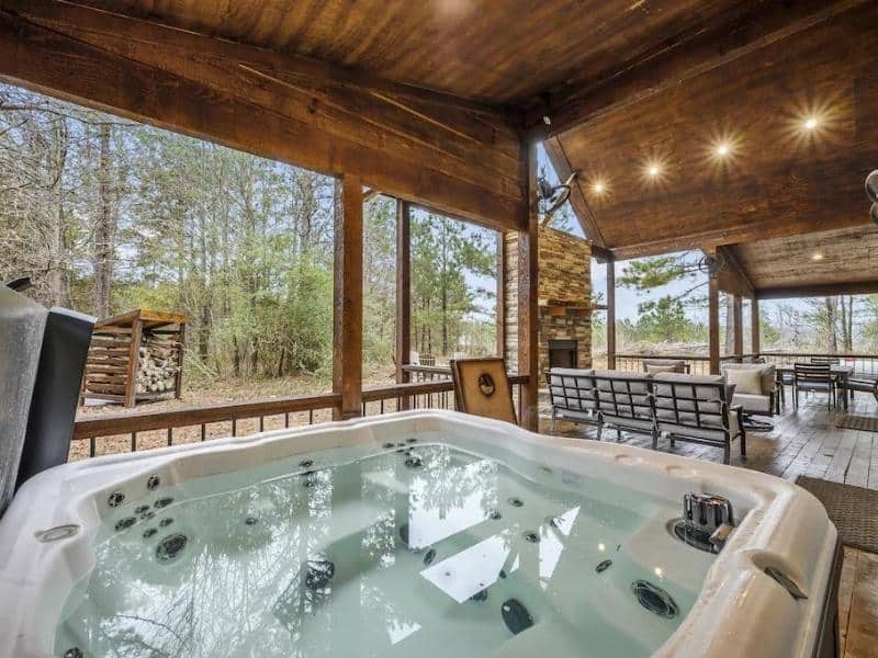 Outdoor entertainment area with hot tub at a Broken Bow Luxury Cabin