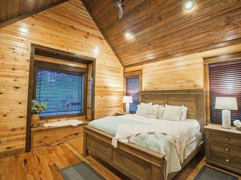 Comfortable bedroom with a wooden bed frame and matching furniture in a cabin rental in Broken Bow.