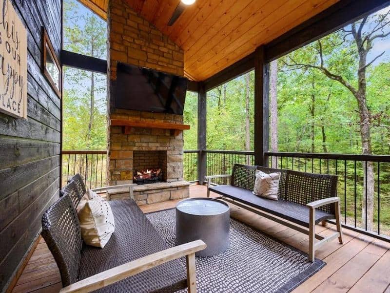 Outdoor patio with fireplace at Saloon Creek Lodge Luxury Cabin, Broken Bow