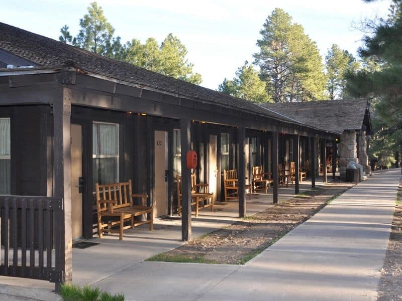 Motel rooms at Grand Canyon North Rim Lodge with long covered porch and wooden benches outside rooms