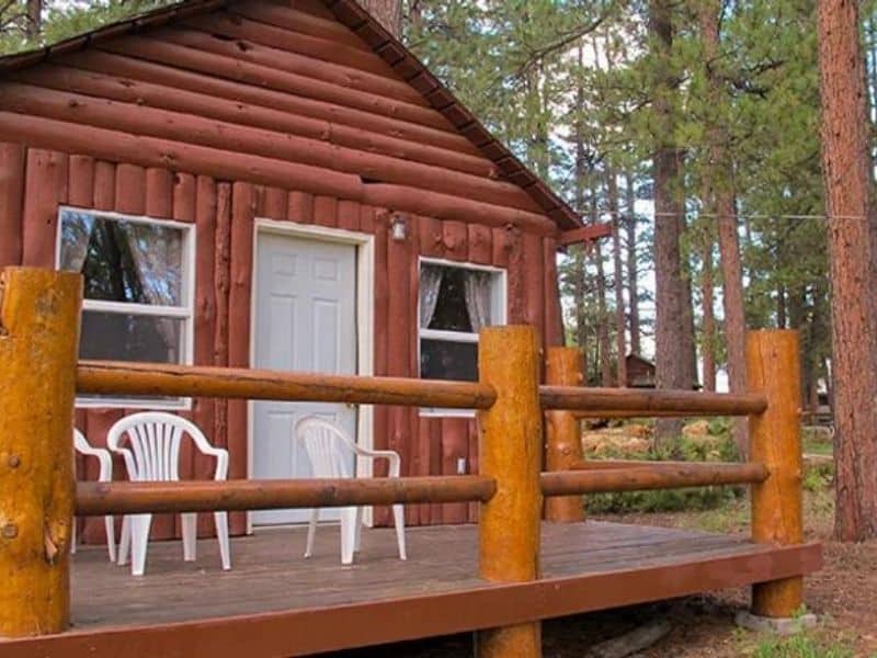Exterior of rustic cabin lodging at Jacob Lake Inn with front porch and seating