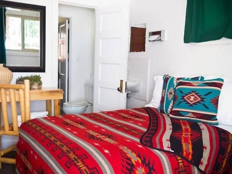 Interior of guest suite at Jacob Lake Inn with ensuite bathroom and colorful aztec style bedding