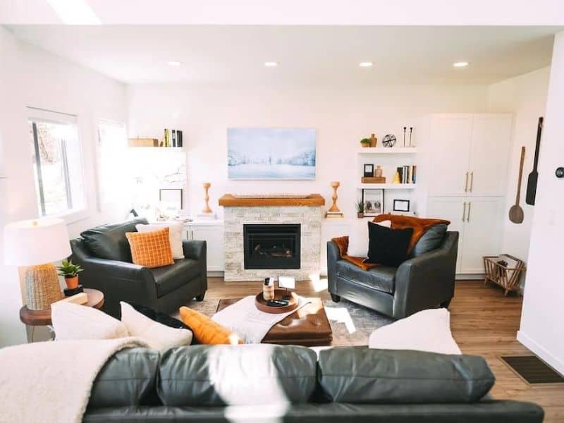 Bright and stylish living room in a Hocking Hills luxury cabin with plush leather sofas, a cozy fireplace, and chic home decor.