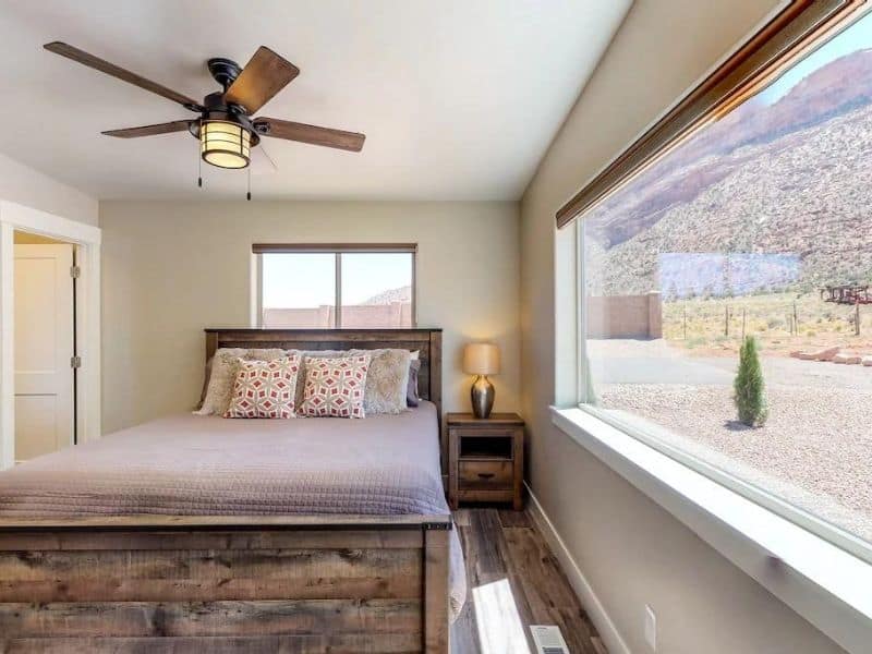 Comfortable bedroom with a large window offering stunning desert views in a Airbnb in Moab.