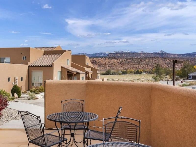 Patio view of a Moab Airbnb showcasing a cozy outdoor seating area with a backdrop of mountains.