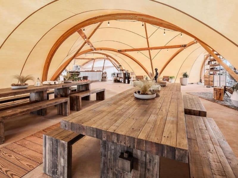 Canvas tented restaurant at Under Canvas Grand Canyon with wood tables and bench seating