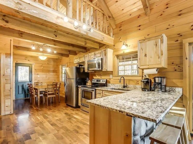 Fully-equipped kitchen with natural wood cabinetry and modern appliances in a Hocking Hills luxury cabin.