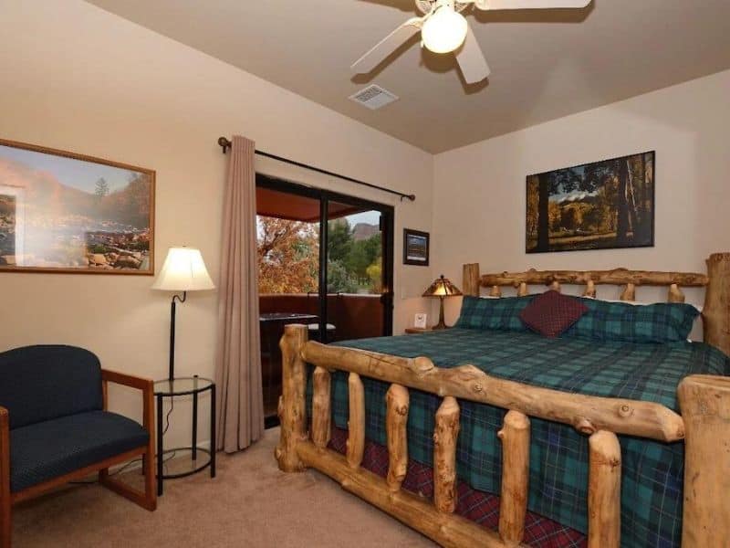 Master bedroom in a Sedona Vrbo with large bed and rustic furnishings.