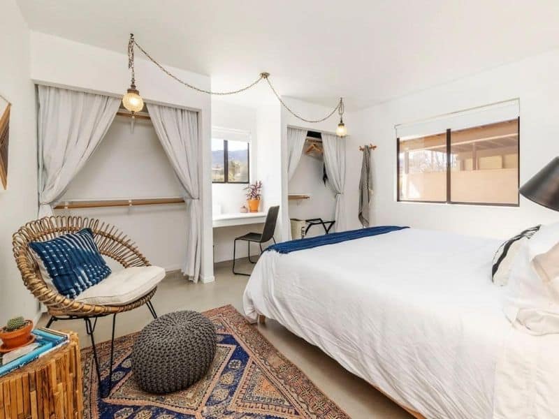 Simple white bedroom in Joshua Tree Airbnb with colorful accents.