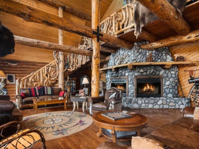 Rustic reception interior at Bar N Ranch near West Yellowstone with stone fireplace and large exposed log beams