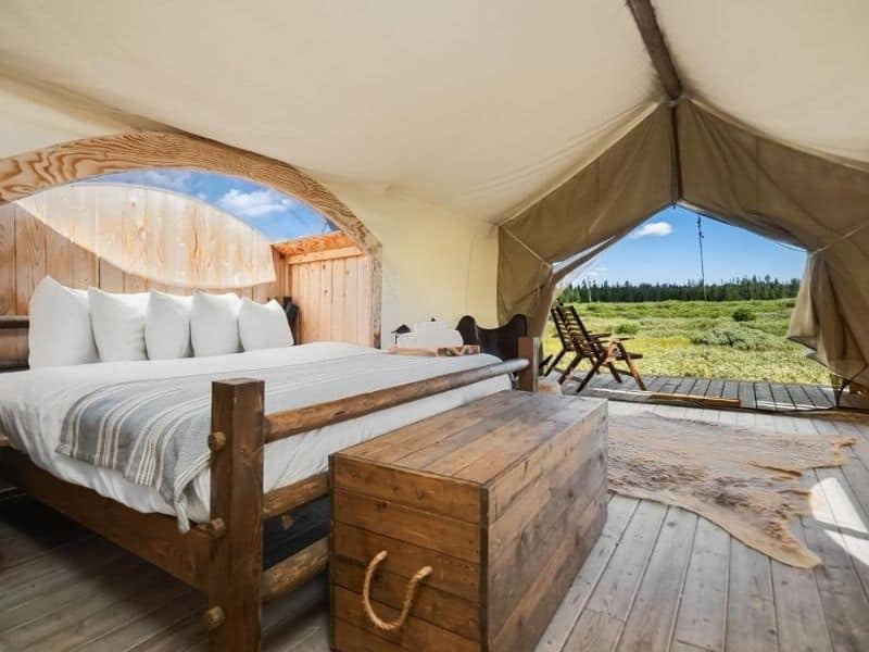 Glamping tent interior at Under Canvas West Yellowstone with king bed, sky viewing window, and private deck