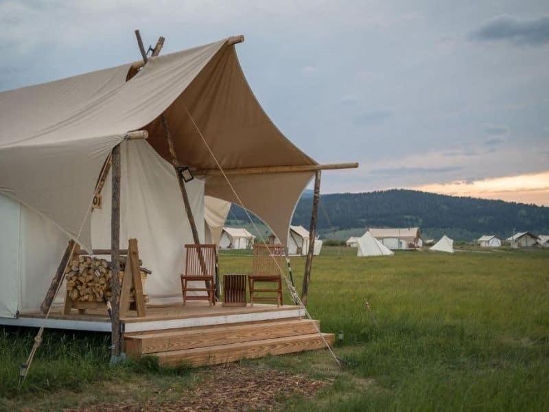 Exterior of canvas tent glamping at Under Canvas West Yellowstone with covered porch and seating