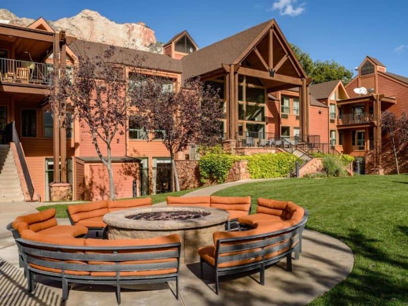 Exterior of Holiday Inn Express in Springdale with red rocks in the background, one of the best value Zion National Park lodging options.