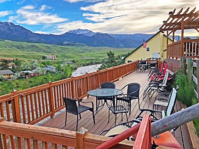 Large elevated deck with table and chairs overlooking the Yellowstone River in Gardiner MT, near Yellowstone National Park's North Entrance.