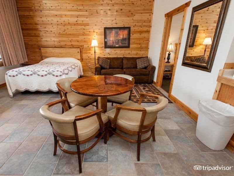 Guest room at Yellowstone Village Inn with queen bed, dining table, and couch