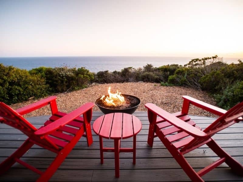 Chairs and fire pit on a deck overlooking the ocean at Treebones Resort in Big Sur