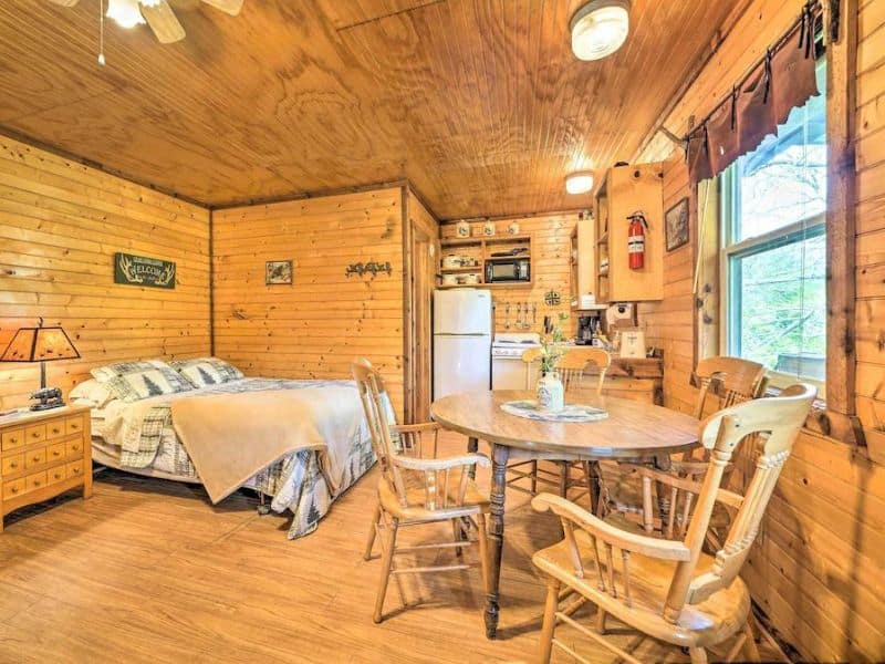 Bed, dining table and kitchen of a rustic cabin near Turner Falls, OK