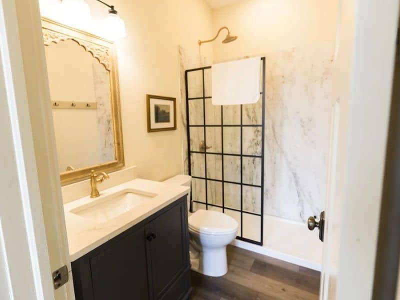 A chic bathroom with a large mirror and a walk-in shower, found in a Hocking Hills cabin rental for 2, combining modern amenities with rustic charm.