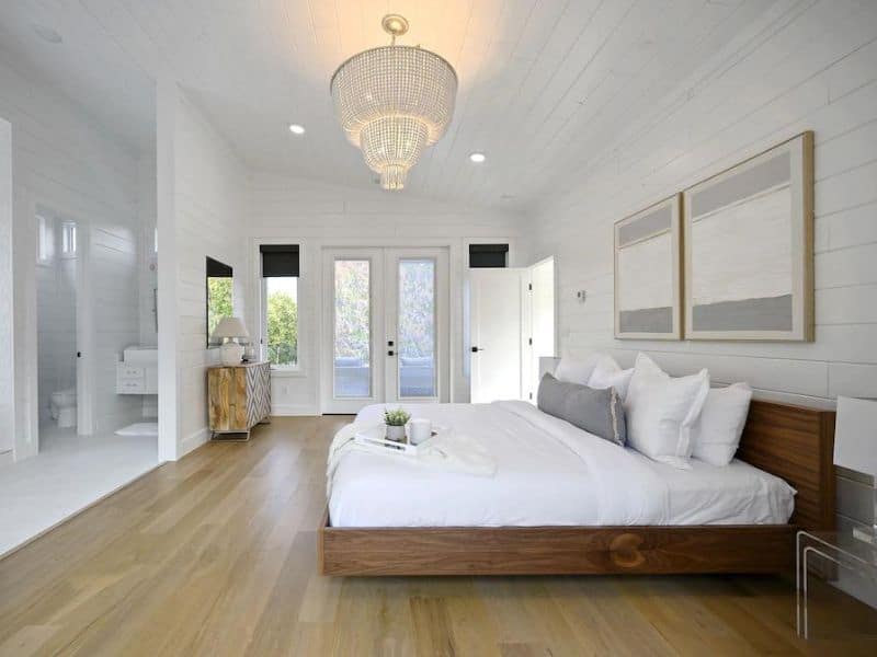 Bright and airy master bedroom with elegant decor, a large bed, and a luxurious en-suite bathroom in 'Casa Arbol' in Broken Bow, OK.