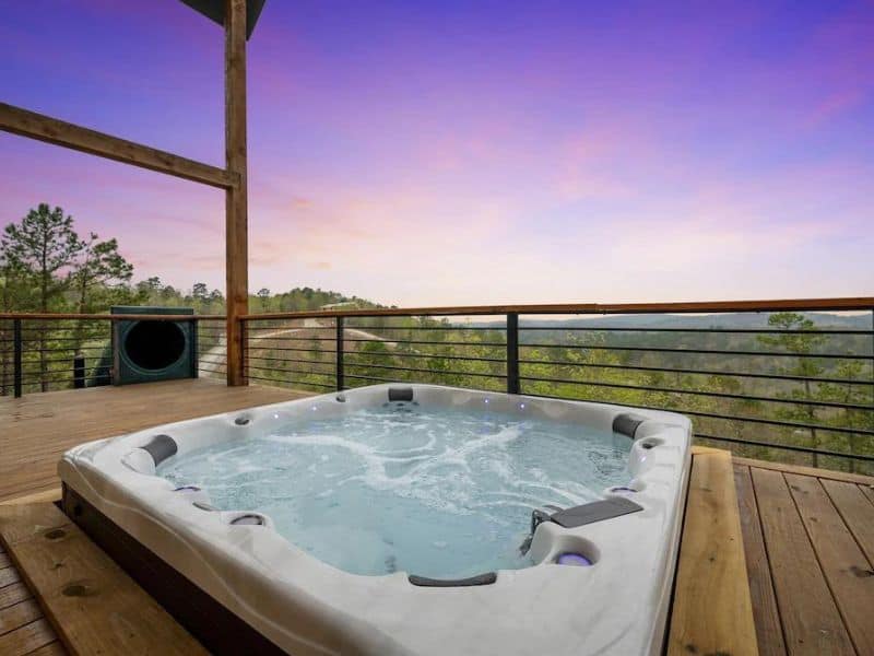 Hot tub on the deck of 'Hell Of A View' cabin in Broken Bow with a panoramic view of the forest.