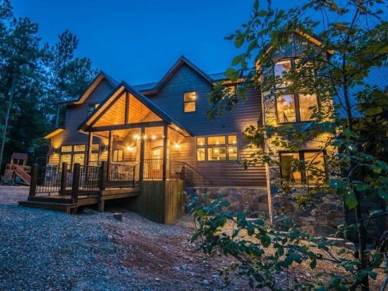 Twilight view of the Lion and The Lamb Lodge, a spacious 5-bedroom cabin in Broken Bow, illuminated with warm outdoor lighting.