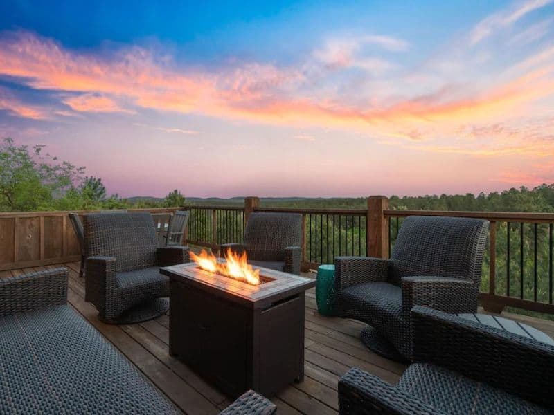 Outdoor deck with fire pit and seating at 'More Than A View,' a Broken Bow cabin rental on Vrbo.