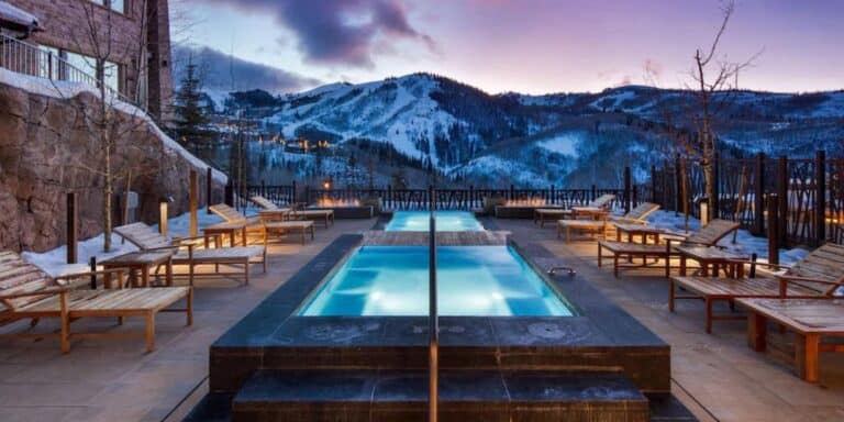 Pool and loungers with snowy mountain view at luxury ski in ski out condo at Empire Pass in Park City, Utah -