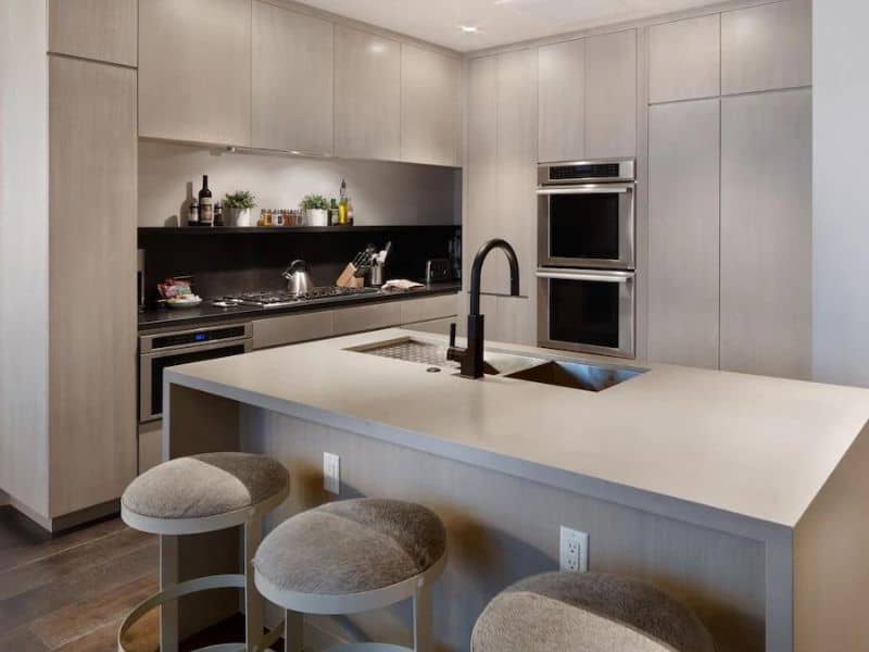 Modern gourmet kitchen in a Luxe Empire Pass Ski In Ski Out Condo in Park City with stainless steel appliances, granite countertops, and a central island with bar seating.