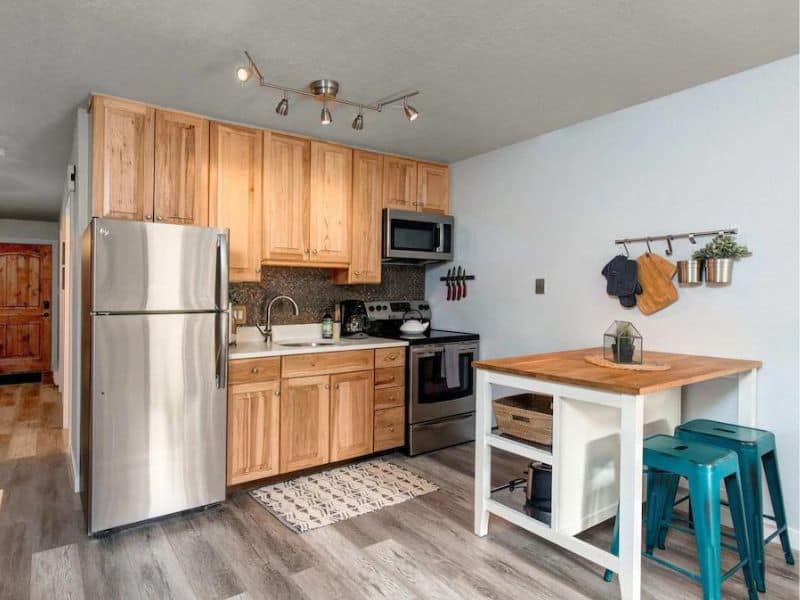 Functional kitchen space with wooden cabinetry and modern appliances in a ski in ski out Snowcrest Condo rental in Park City, UT.