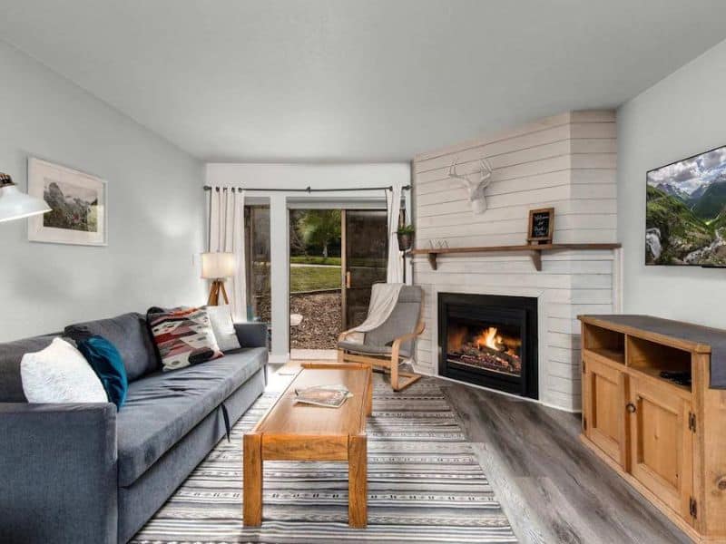 Inviting living room with a white shiplap fireplace and sliding doors leading to an outdoor area at Snowcrest Condo in Park City, UT.