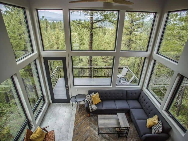 Modern cabin rental with floor to ceiling windows overlooking a forest outside Pagosa Springs, CO