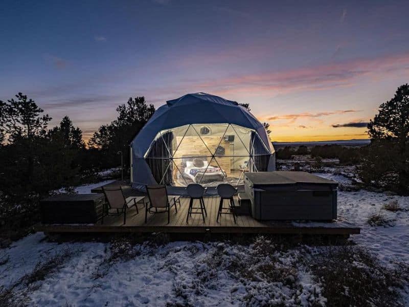 Geodome lit up at sunset on wooden deck with hot tub near Great Sand Dunes National Park, CO