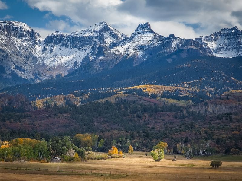 Snow capped Rocky Mountains in Colorado with fall colors in the foreground