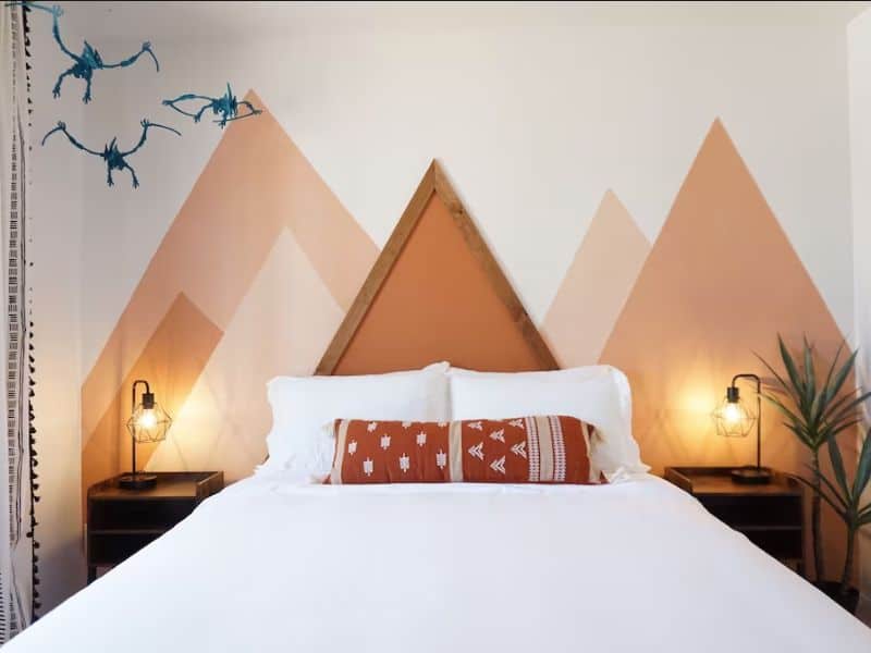 Bedroom in dinosaur themed Vrbo in Page, Arizona with mountain headboard and dinosaur mobile.