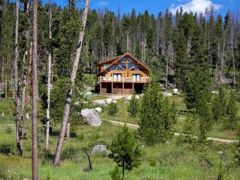 True log cabin rental surrounded by forest in Rocky Mountain National Park, CO