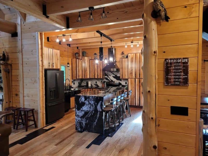 Modern kitchen with black marble island and black appliances in Hocking Hills cabin rental