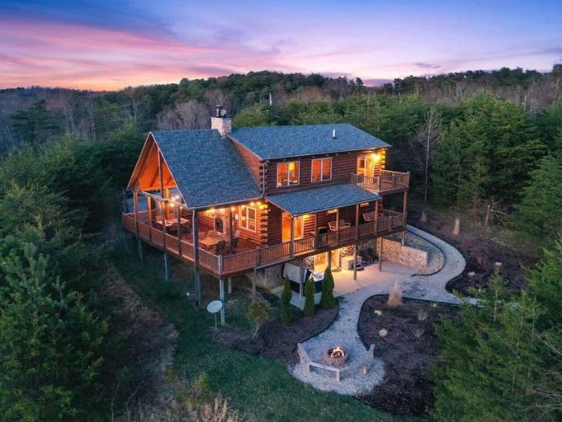 Aerial view of large wood cabin in Hocking Hills at dusk with a fire pit and outdoor seating