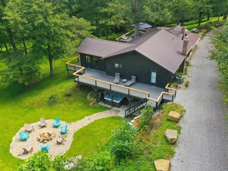 Aerial view of Scenic Grove Retreat Hocking Hills cabin with outdoor fire pit and covered hot tub.