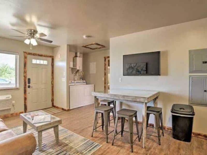 Small table with barstools and living area with tv, washer, and dryer at Moab airbnb