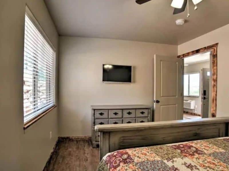 Queen bedroom with quilted bed and tv at quiet single-bedroom Moab airbnb for two